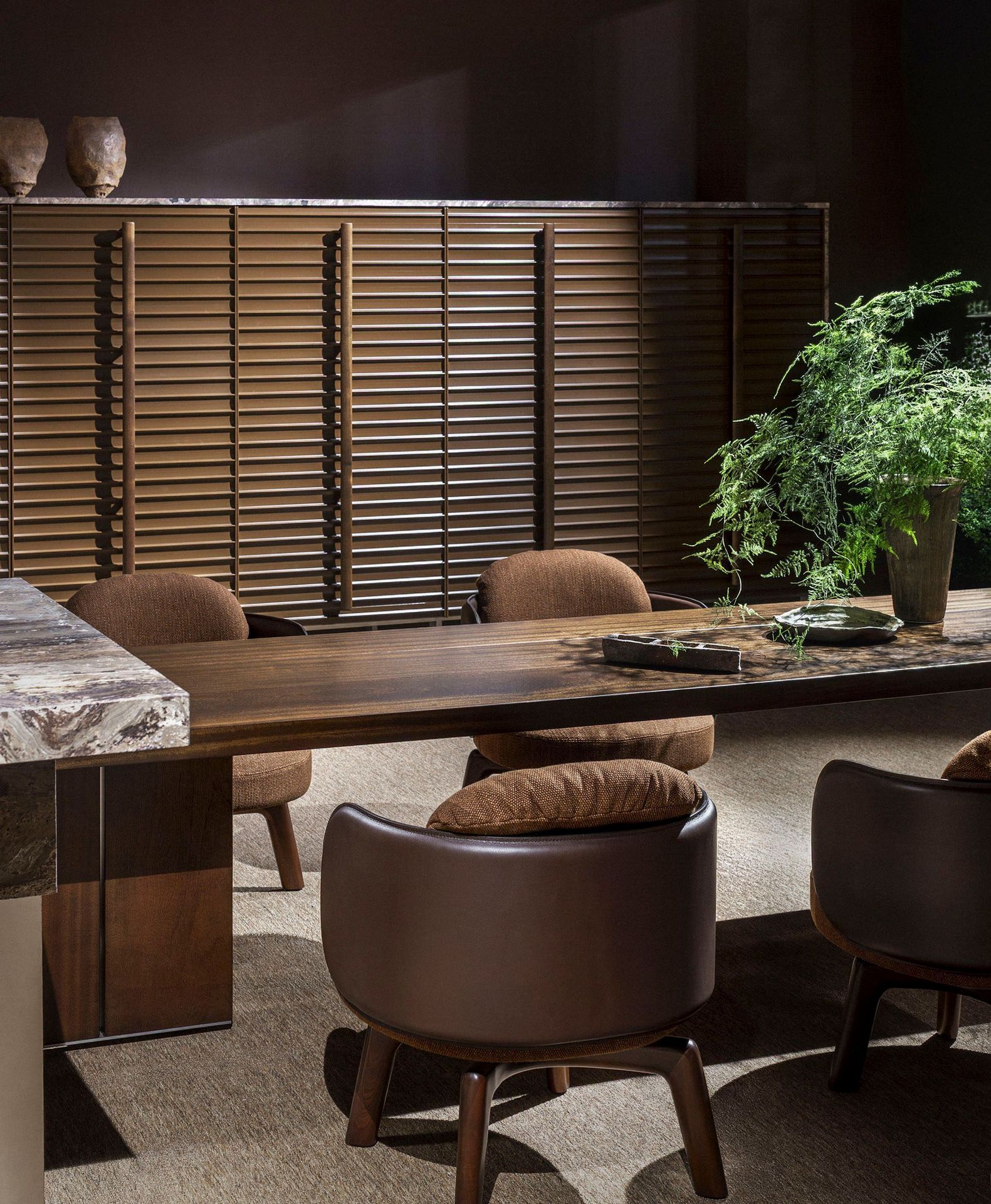 A dark, atmospheric dining collection in rich wood and stone